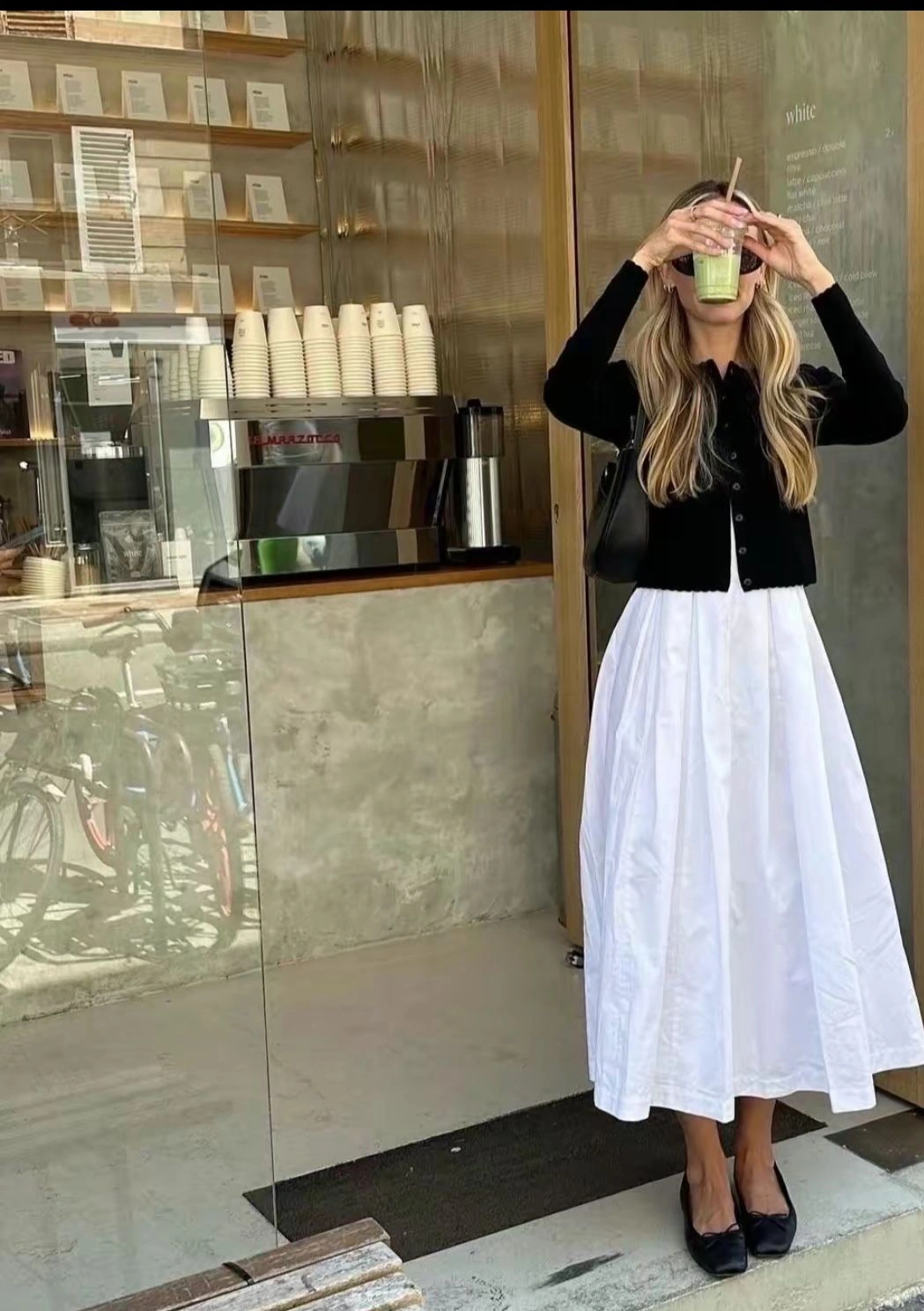 Пишна біла спідниця міді з чорним кардиганом і чорними балетками з бантами